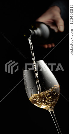 Pouring white wine in a glass. Pouring white wine in a glass. 123498815