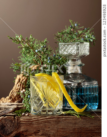 Cocktail gin-tonic with ice, lemon, and rosemary in a frozen glass. Cocktail gin-tonic with ice, lemon, and rosemary in a frozen glass. 123498928