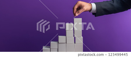 Hand stacking blocks to symbolize growth and progress 123499445