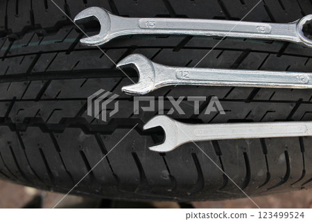 Repairing Wrenches Lying On A New Car Tire Top View Repairing Wrenches Lying On A New Car Tire Top View 123499524