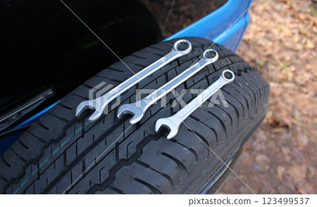 Steel spanners on the spare wheel attached to the trunk door of the car Steel spanners on the spare wheel attached to the trunk door of the car 123499537