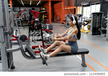 young woman exercising using tools in a sitting position young woman exercising using tools in a sitting position 123499905