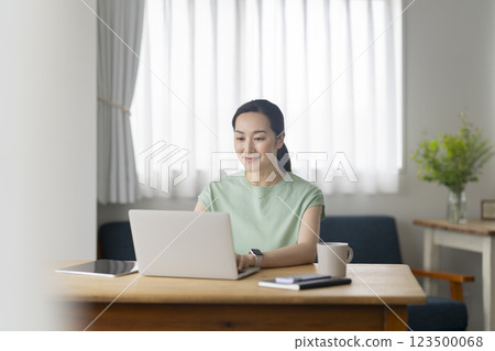 30 多歲的女性在家使用筆記型電腦工作，圖片 123500068