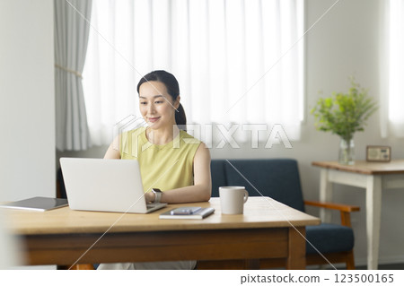 30 多歲的女性在家使用筆記型電腦工作，圖片 123500165