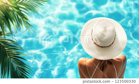 Woman in Sun Hat Relaxing by Poolside 123500330
