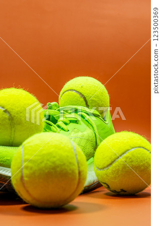 Tennis balls with sneakers on an orange background. Tennis balls with sneakers on an orange background. 123500369