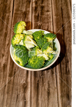 Plate with broccoli on a wooden table Plate with broccoli on a wooden table 123500371