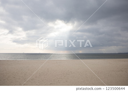 Sun shining through clouds on empty beach by the Baltic sea 123500644
