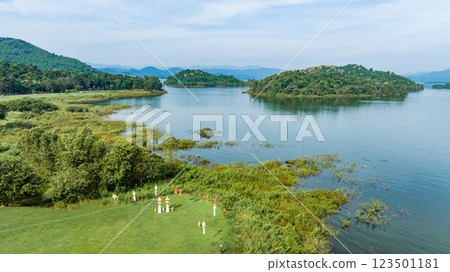 Kaeng Krachan dam with lake view and many green moutain, blue sky background. Kaeng Krachan Dam national park, Phetchaburi province, Thailand in aerial view from drone. 123501181