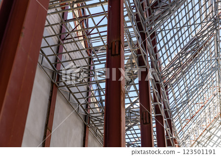 Uprisen angle photo shot of the huge steel roof frame structure detail under construction at the work site. 123501191