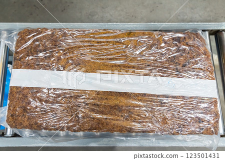 The natural rubber bales products on the industrial automatic conveyor belt machine in a rubber factory. 123501431