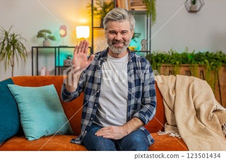 Happy mature man smiling friendly at camera, waving hands gesturing hello, hi, greeting, welcome Happy mature man smiling friendly at camera, waving hands gesturing hello, hi, greeting, welcome 123501434