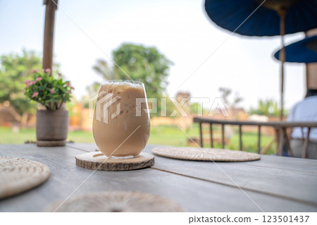 Ice coffee at outdoor garden in the morning on vintage wood table showing the texture of ice on glass. 123501437