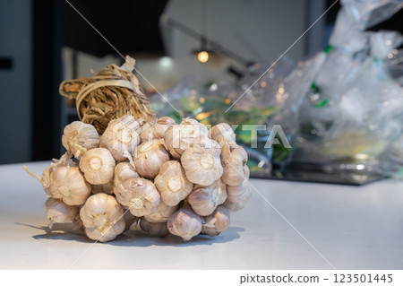 Garlic Bundle in studio light on the white marble surface table, prepare for a food demonstration behind. 123501445