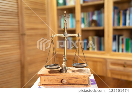 Classic Golden Scale in vintage mood and tone lays on book pile or tower. 123501474