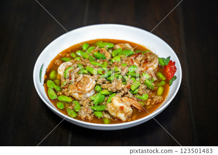 Thai Stir-Fried Stink Beans with Shrimps and spicy shrimp paste sauce in white dish bowl on dark wood table. Clipping Path. Thai Stir-Fried Stink Beans with Shrimps and spicy shrimp paste sauce in white dish bowl on dark wood table. Clipping Path. 123501483