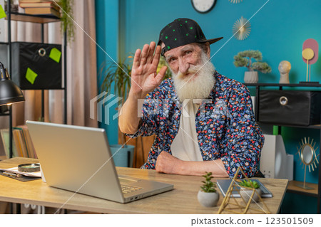 Happy senior man waves hand hi hello gesture greeting welcomes someone online webinar conversation Happy senior man waves hand hi hello gesture greeting welcomes someone online webinar conversation 123501509
