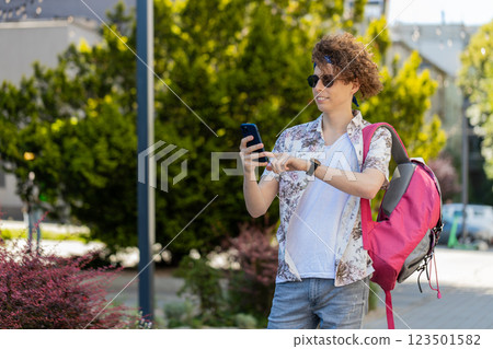 Happy tourist man using smartphone typing text messages browsing internet social media web app 123501582