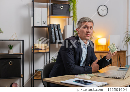 Upset businessman freelancer counting dollar cash insufficient amount of money at home office desk Upset businessman freelancer counting dollar cash insufficient amount of money at home office desk 123501604