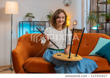 Happy Caucasian young woman finishing assembling furniture after moving into new apartment home 123501627