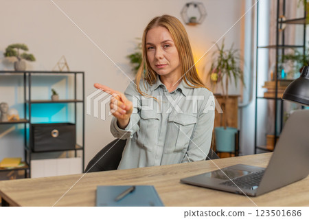 Displeased Caucasian woman freelancer shake finger No sitting at home office desk in living room Displeased Caucasian woman freelancer shake finger No sitting at home office desk in living room 123501686