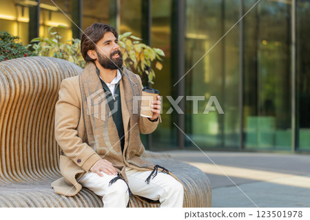 Happy Indian business man tourist enjoying morning coffee hot drink walking on city downtown street 123501978