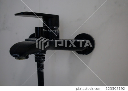 Lime deposits on black bathroom faucet at home 123502192