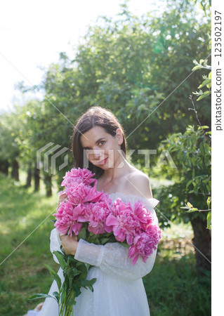 Brunette girl with pink peonies bouquet portrait Brunette girl with pink peonies bouquet portrait 123502197