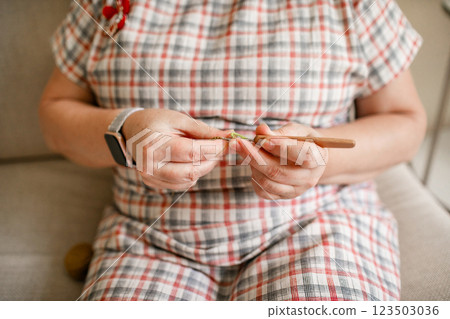 Close-up view of hands of an older woman crocheting Close-up view of hands of an older woman crocheting 123503036