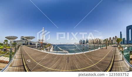 Dubai Marina featuring high rise buildings, a yacht harbor, and a lively promenade 123503752
