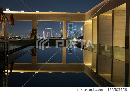 The illuminated Dubai skyline reflecting in a rooftop pool at night 123503758