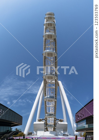 Dubai Marina Ferris wheel viewed from below against blue sky 123503769