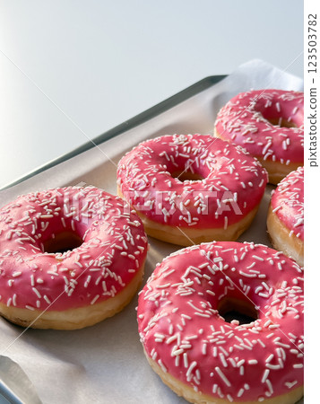 Pink donuts on metal tray and white table close up Pink donuts on metal tray and white table close up 123503782
