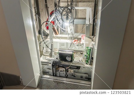 Inspection of Elevator Mechanism featuring Exposed Wiring Components for Safety and Functionality, Elevator doors open during breakage and repair. Elevator maintenance, emergency situation. mine and Inspection of Elevator Mechanism featuring Exposed Wiring Components for Safety and Functionality, Elevator doors open during breakage and repair. Elevator maintenance, emergency situation. mine and 123503821