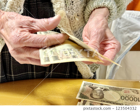一位老婦人在清點新版一萬日元鈔票 123504332
