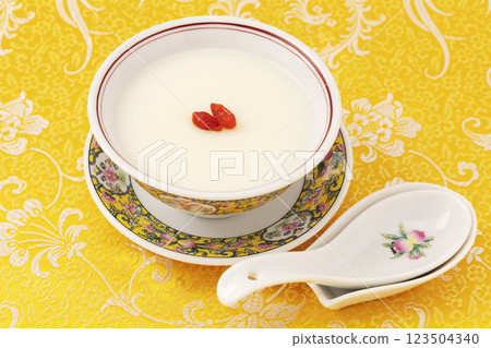 黃色布料背景上用黃色中國碗製成的杏仁豆腐 123504340