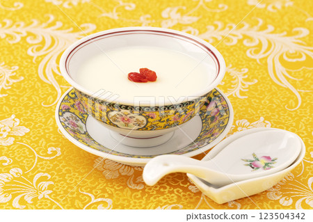 Almond tofu made in a yellow Chinese bowl on a yellow fabric background 123504342