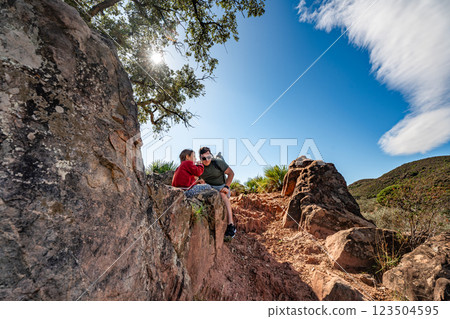 Father and child hiking in sunny rocky landscape with blue sky 123504595