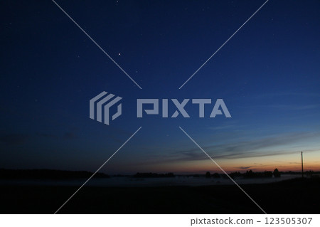 Starry Night Sky Over a Misty Landscape Starry Night Sky Over a Misty Landscape 123505307