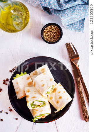 wrapped tortilla sandwich rolls cut in half and ingredients 123505599