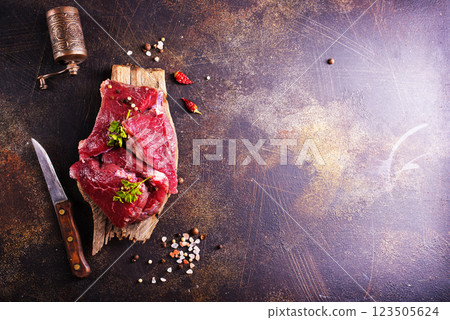 Raw marbled beef steaks on a dark slate, stone or concrete background . Raw marbled beef steaks on a dark slate, stone or concrete background . 123505624