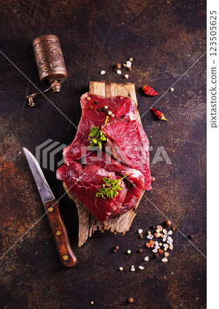 Raw marbled beef steaks on a dark slate, stone or concrete background . Raw marbled beef steaks on a dark slate, stone or concrete background . 123505625
