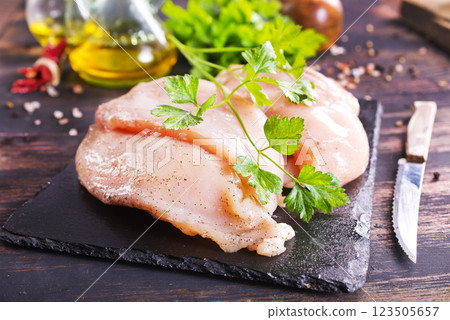 Fresh chicken breast fillet on cutting board with spices, dark rustic background. 123505657
