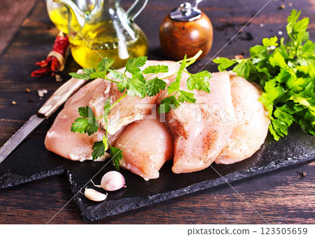Fresh chicken breast fillet on cutting board with spices, dark rustic background. Fresh chicken breast fillet on cutting board with spices, dark rustic background. 123505659