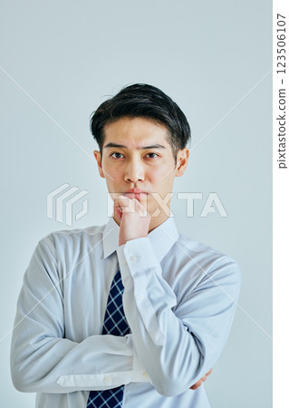 A young man in a shirt thinking 123506107