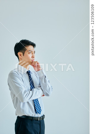 一個穿著襯衫的年輕人在思考 123506109