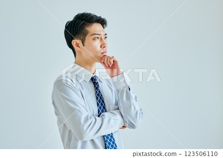 一個穿著襯衫的年輕人在思考 123506110