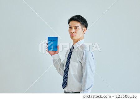 A young man in his 20s holding a pension book 123506116