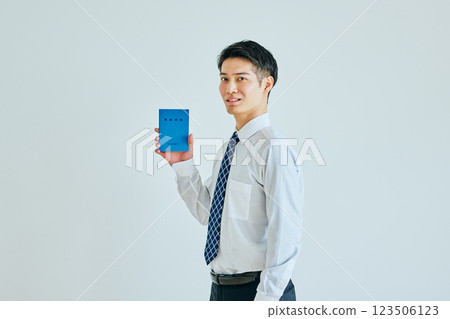 A young man in his 20s holding a pension book 123506123