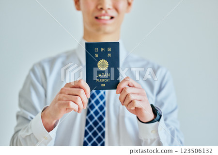 A young man in his twenties holding a passport 123506132